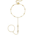 Gold bracelet with pearl-like beads on a white background