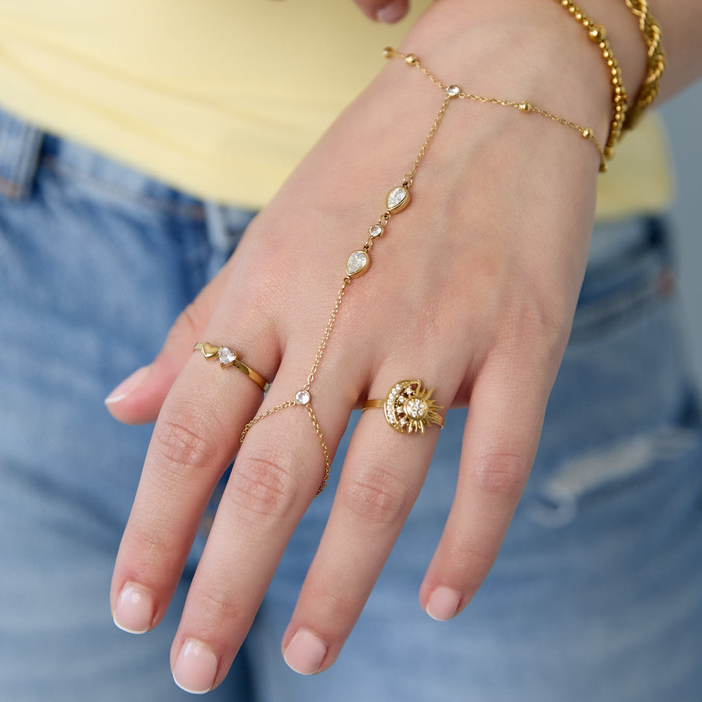Close-up of a hand wearing gold jewelry with a blurred background