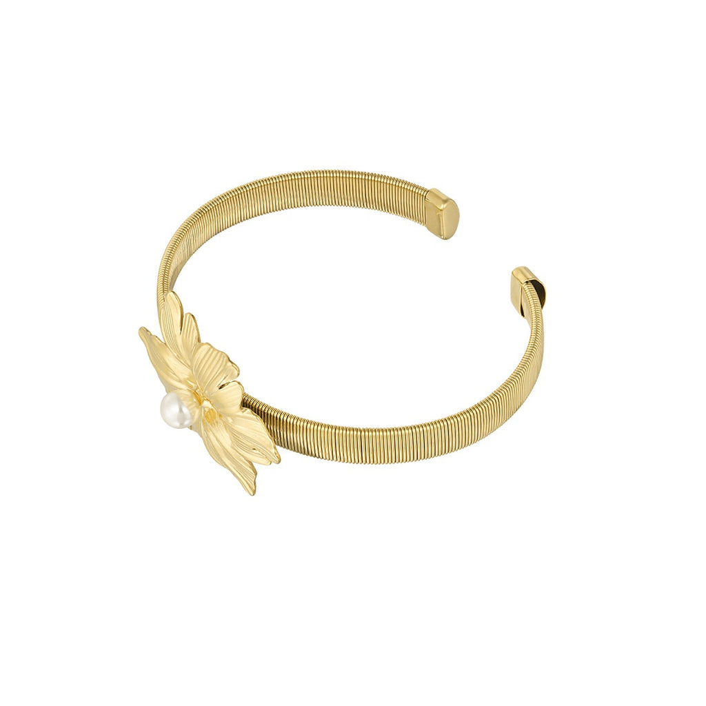 Gold bracelet with a decorative element on a white background